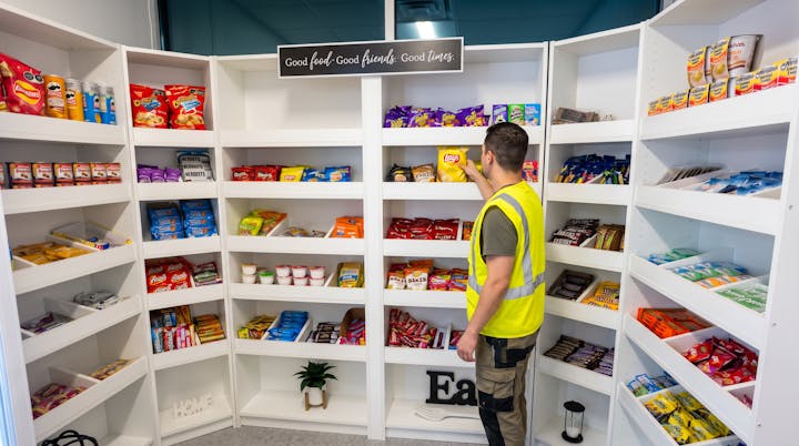 Open shelving stocked with chips, crackers, candy and instant noodles.