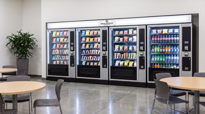 Row of modern SnackSpot vending machines in a break room.